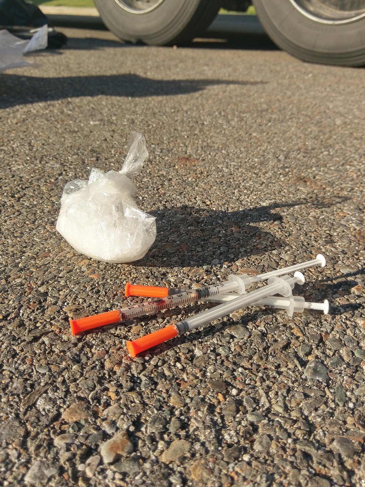 A closer look at the seized methamphetamine with used syringes.
