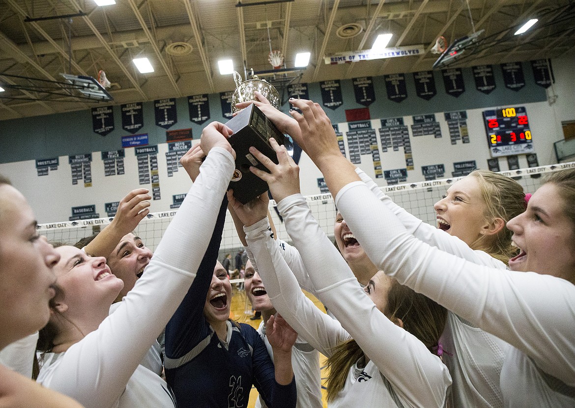 LOREN BENOIT/Press
The Lake City High School volleyball team hoists its 5A Region 1 Championship trophy in the air after defeating Post Falls Tuesday night.