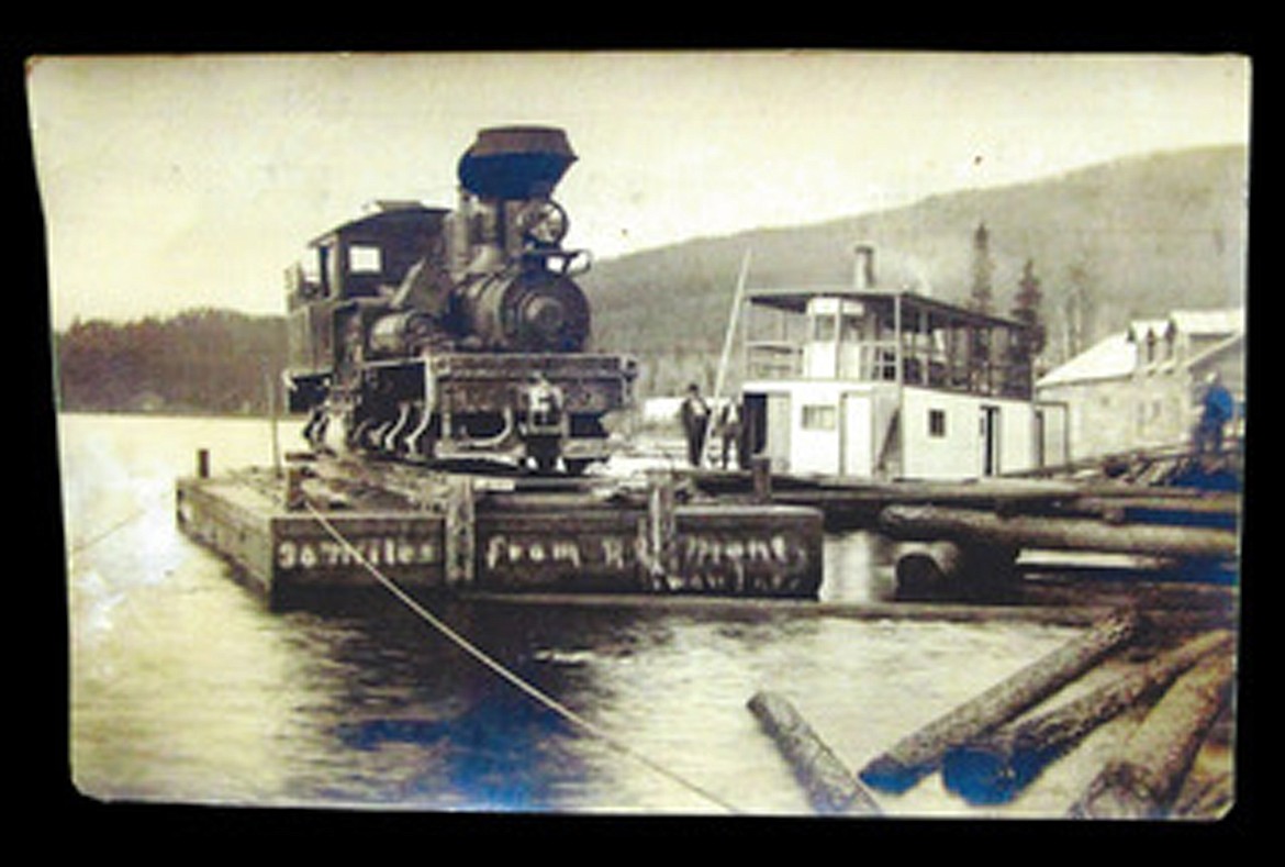 Photograph of a Shay engine on a barge at the dock for the logging camp located at the head of Swan Lake, Montana. &#160;The engine was transported from Somers, Montana, across Flathead Lake on the Ballard barge. &#160;From Bigfork, it was moved on portable rails along the south side of Swan River to the foot of Swan Lake. &#160;The engine was used to pull logs from logging sites, down to Swan Lake. Date 1915Photographer UnknownAttribution: Collection of Denny Kellogg