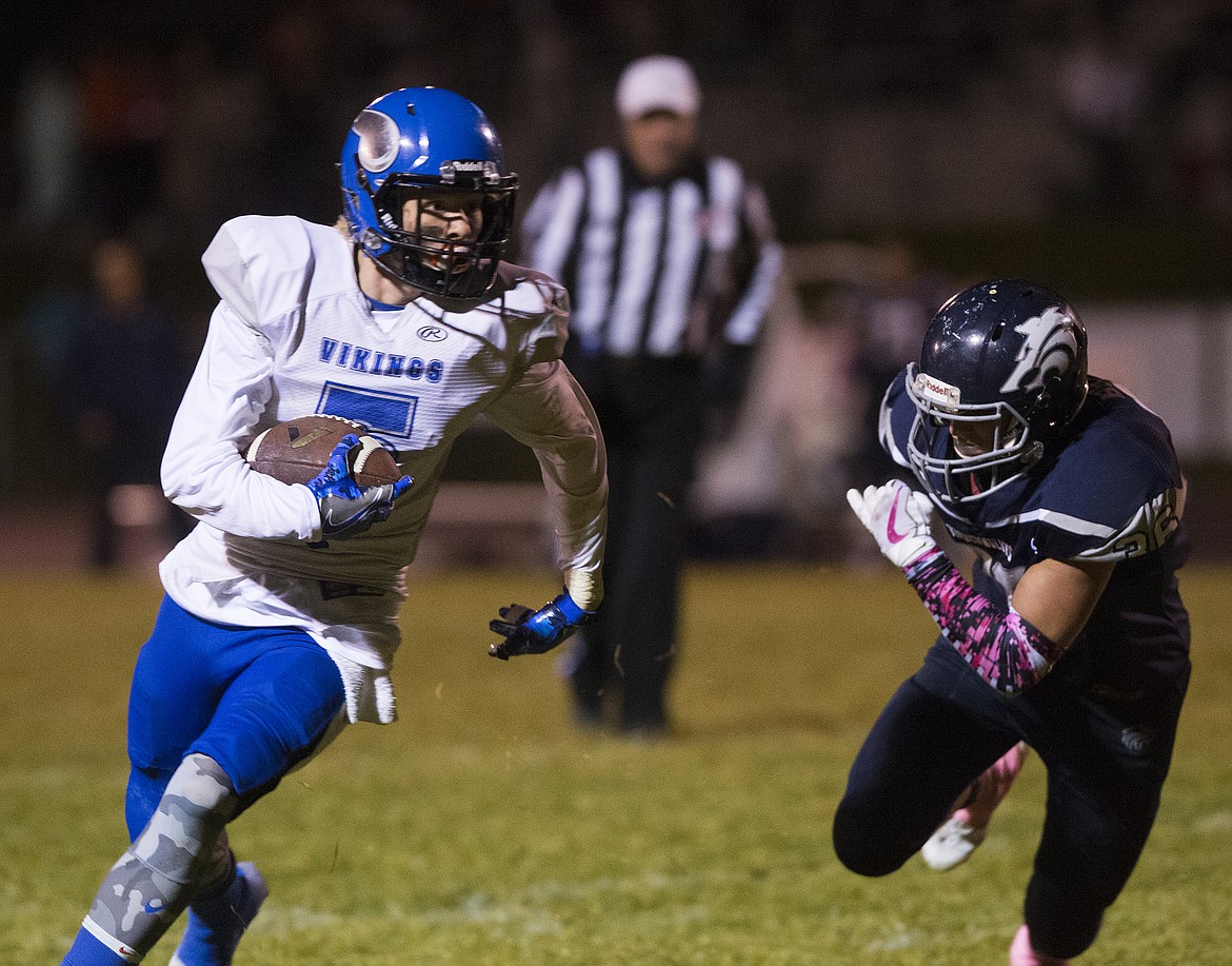 LOREN BENOIT/PressCoeur d'Alene wide receiver Kyler Pendergast runs the ball as Lake City safety Lucas Briner tries to make the tackle.