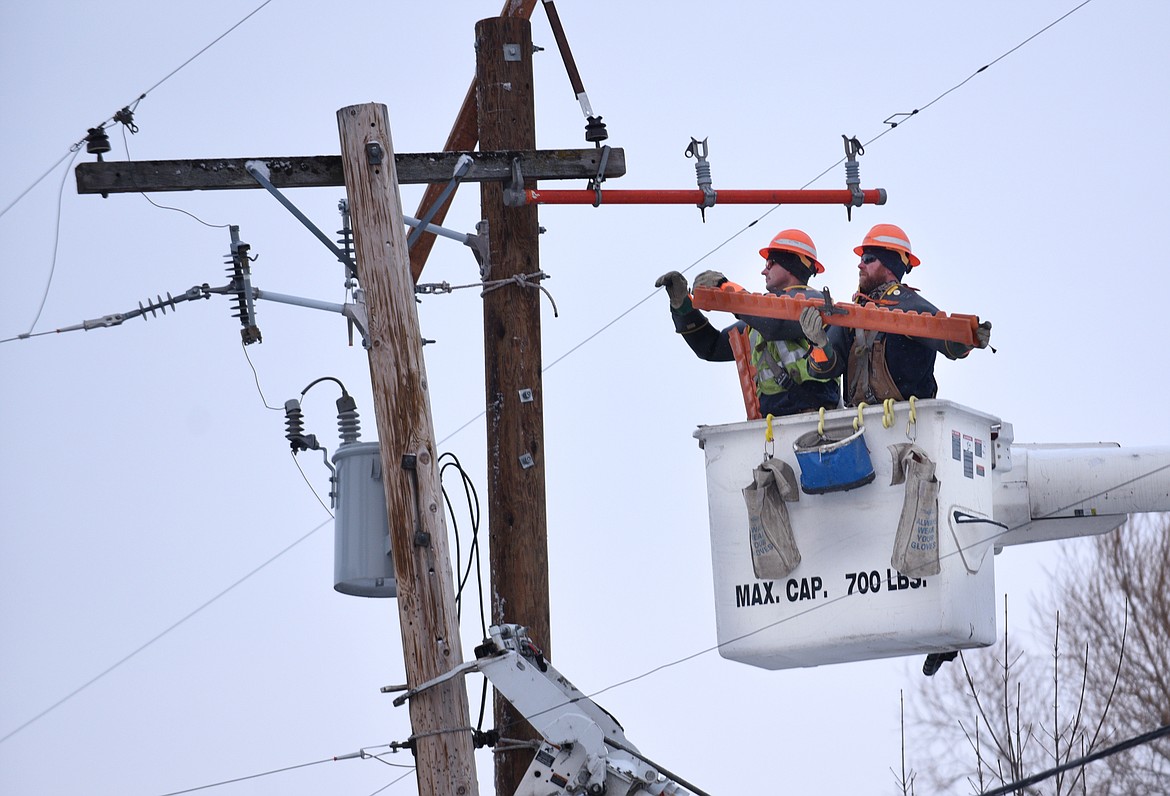 Flathead Electric Cooperative workers repair a power pole and lines in this file photo. (Aaric Bryan/Daily Inter Lake file)