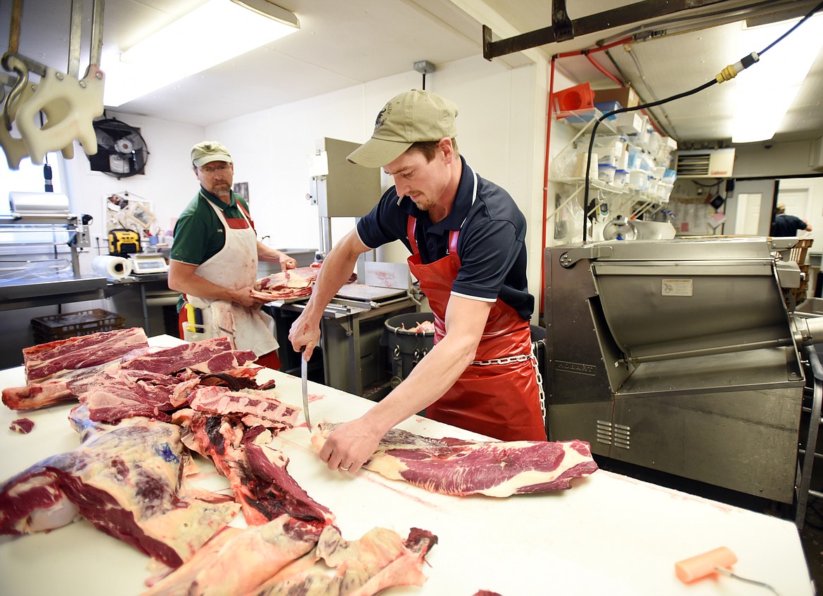 Jeremy Plummer and Jay Arlint process beef at Lower Valley Processing Co. south of Kalispell. (Brenda Ahearn/Flathead Journal)