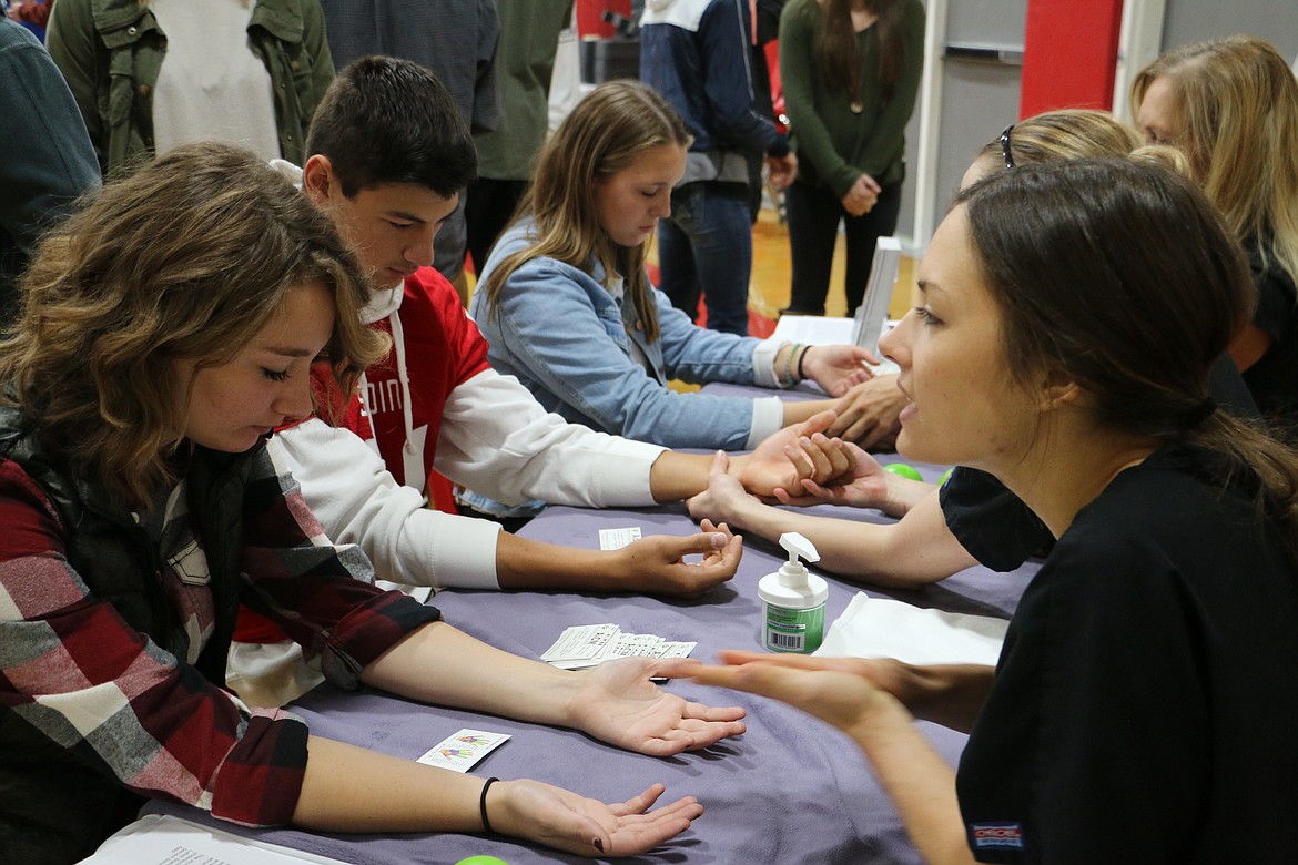 (Photo by MARY MALONE)
The American Institute of Clinical Massage got hands-on, offering hand massages during North Idaho College's Career-Technical Education Roadshow at Sandpoint High School on Friday.