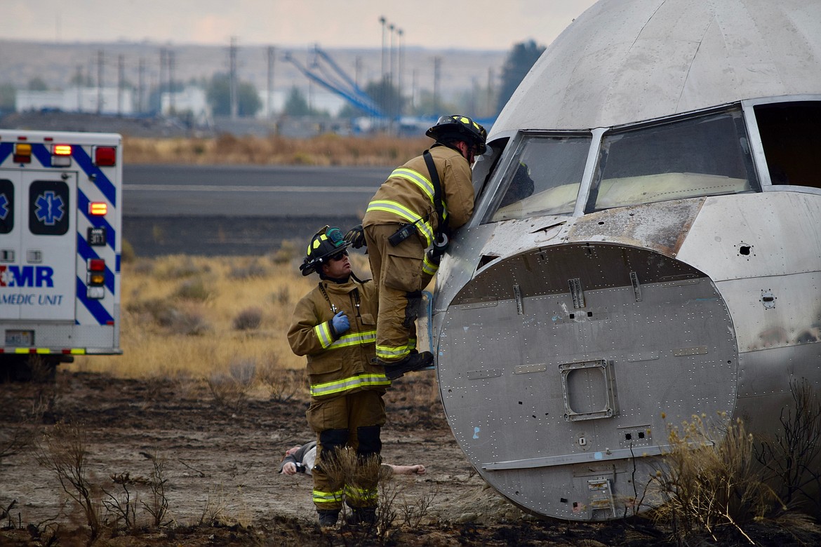 Charles H. Featherstone/Columbia Basin Herald
Firefighters scramble to get inside a &#145;crashed&#146; aircraft during a disaster exercise at the Port of Moses Lake on Friday.