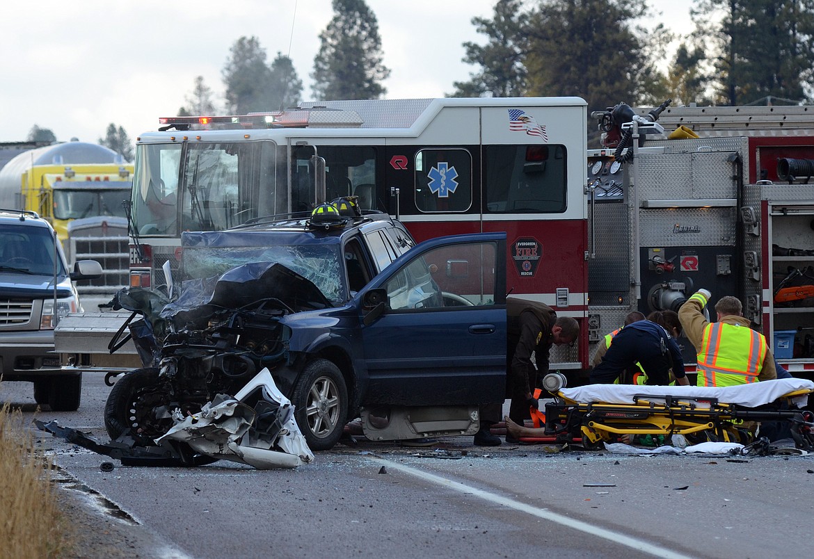 Emergency crews tend to the driver of an SUV following a head-on crash Friday, Oct. 13 on U.S. 2 north of Evergreen. (Matt Baldwin/Daily Inter Lake)