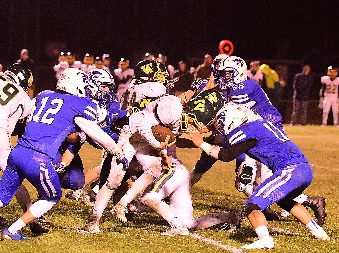 The Cats defense swarms a Whitefish ball carrier.