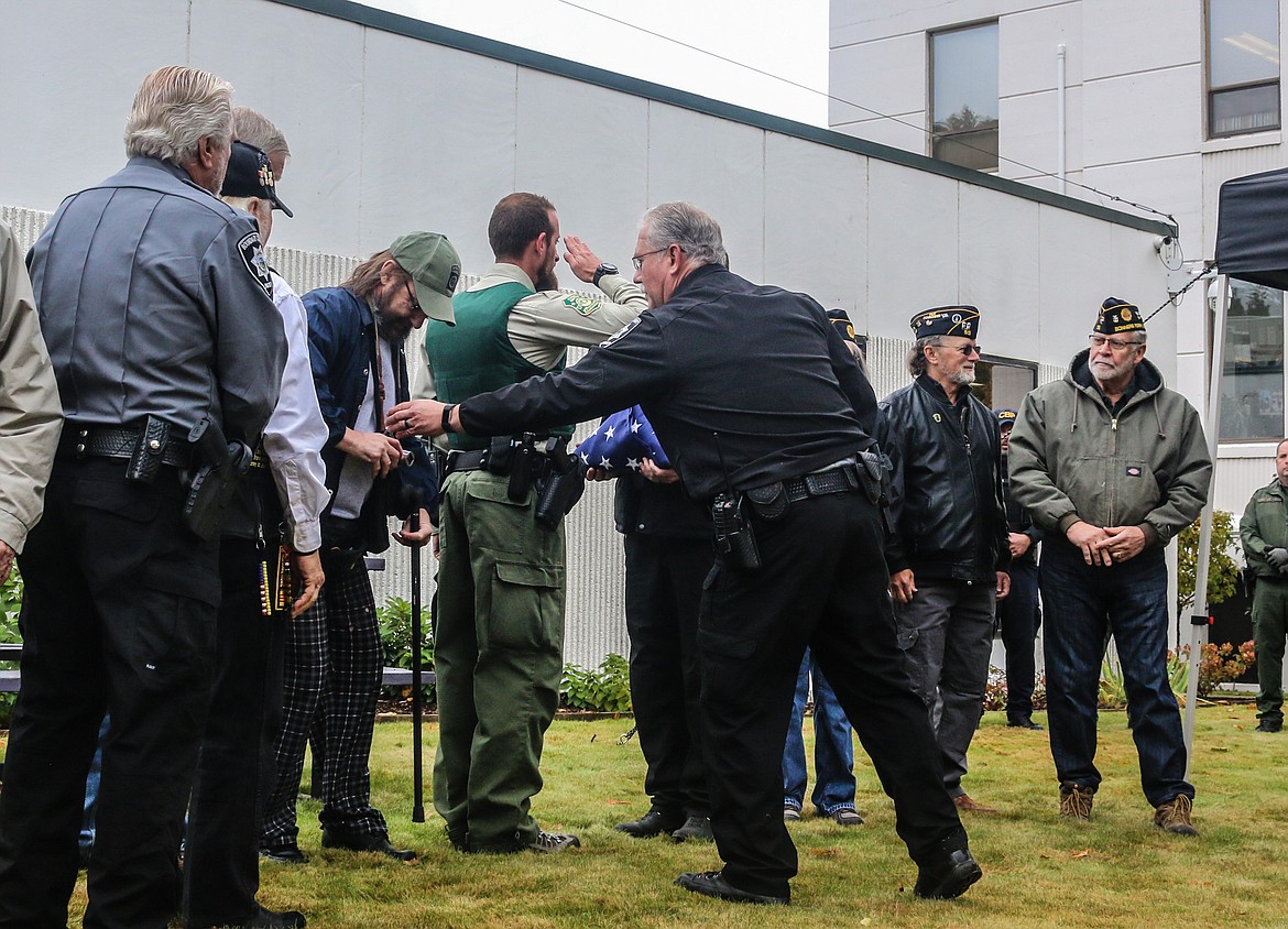 Photo by Mandi Bateman
Boundary County Sheriff Dave Kramer surprises Mike Weland by offering to take his camera so he could accept the flag.