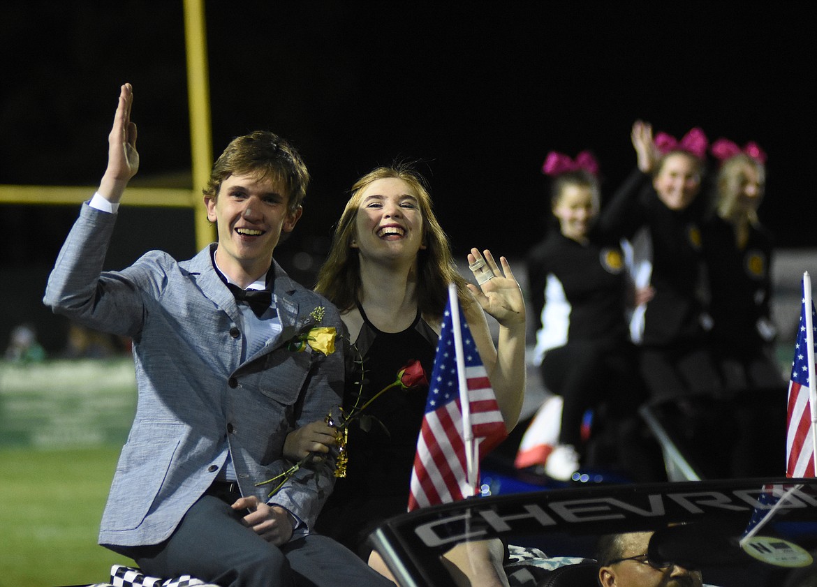 Seth Carmichael and Ella Van Vlack ride down the field during homecoming on Friday.