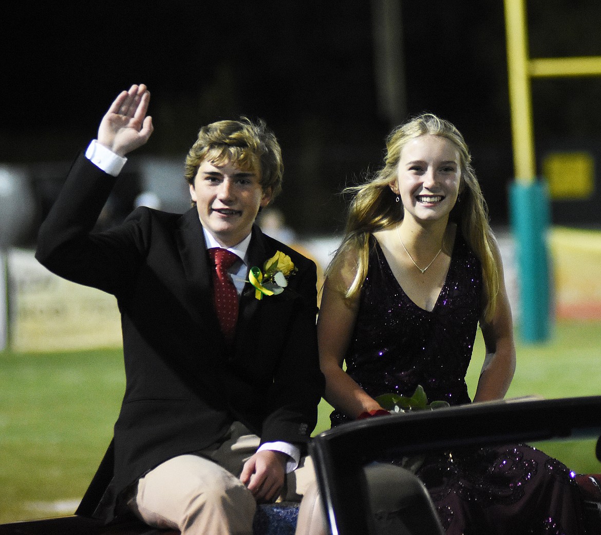 Noah Romagnuolo waves to the crowd as Kendall Reed sits at his side during homecoming celebrations Friday night.