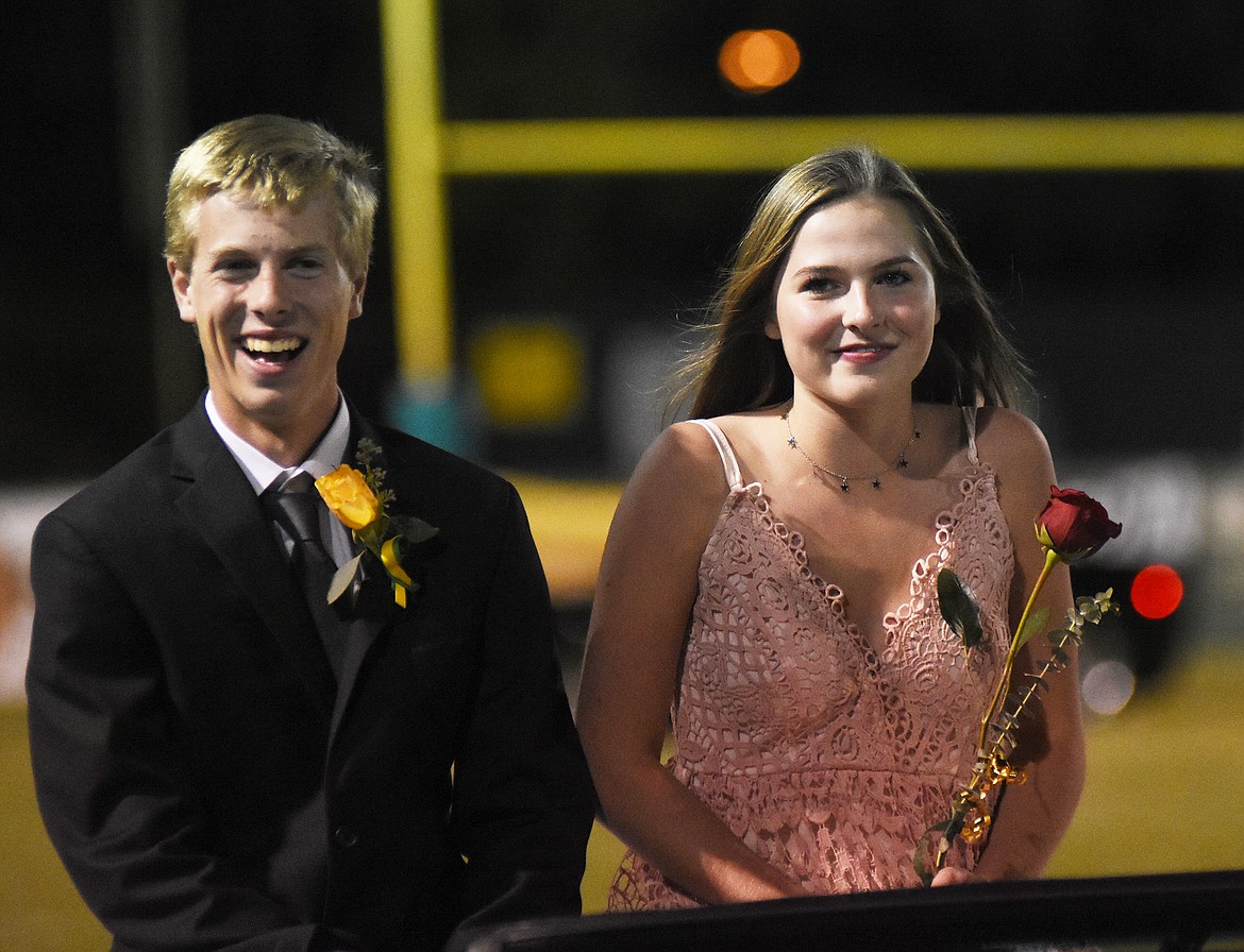 Josh Weller and Claire Carloss enjoy the car ride down the field Friday during homecoming.