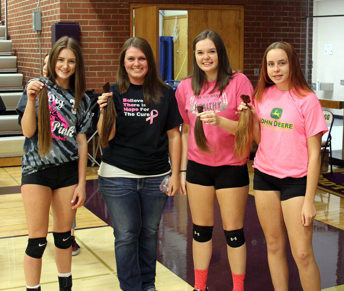 Everyone got in on the fun at Dig Pink Night, including these four ladies who cut off significant chunks of their hair to be donated to Wigs for Kids. Pictured are Kaili Cates, Anali Spooner, Jen Hayman, and Summer Gardner each holding the hair they had cut off.