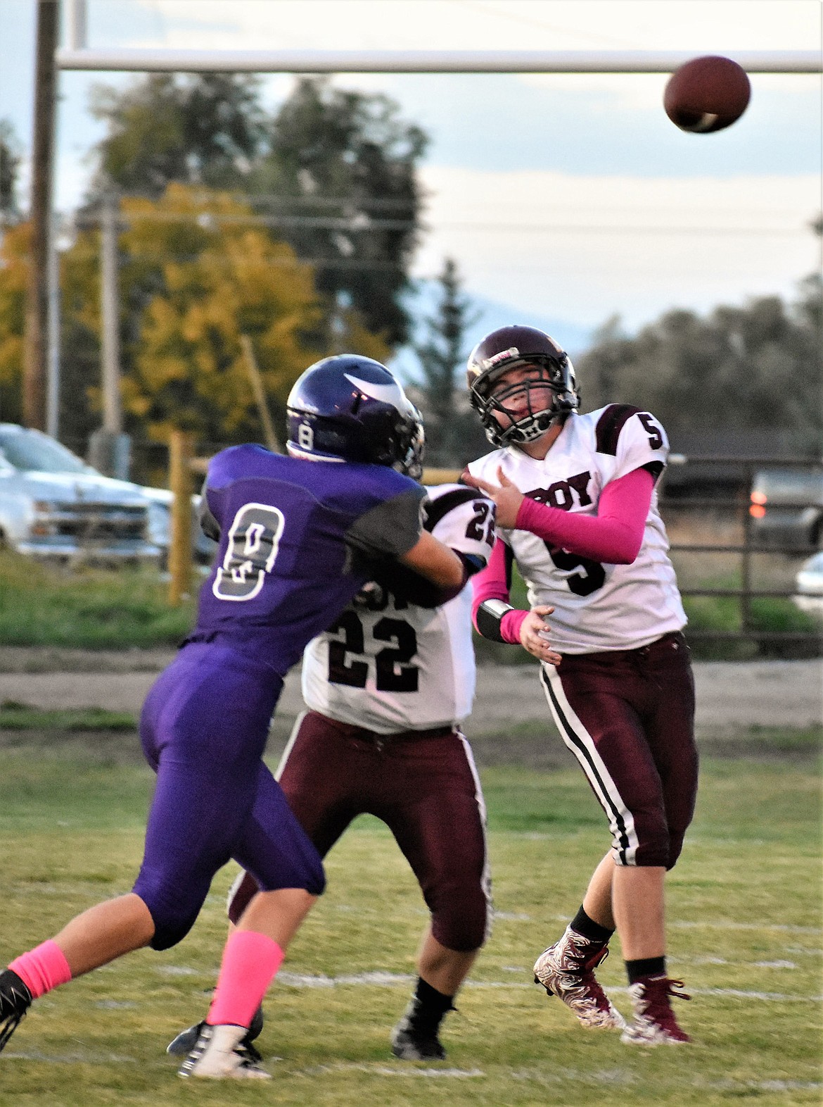 Troy quarterback Cody Osterberg gets off a pass as his teammate Cy Winslow defends him against Charlo's Shad Anderson during Friday night's game in Charlo. (Photo by Svetlana Harper)