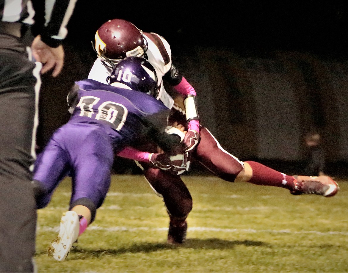 Troy's Dylan Cummings is brought down by Charlo's Roper Edwards during Friday night's game in Charlo. (Photo by Svetlana Harper)