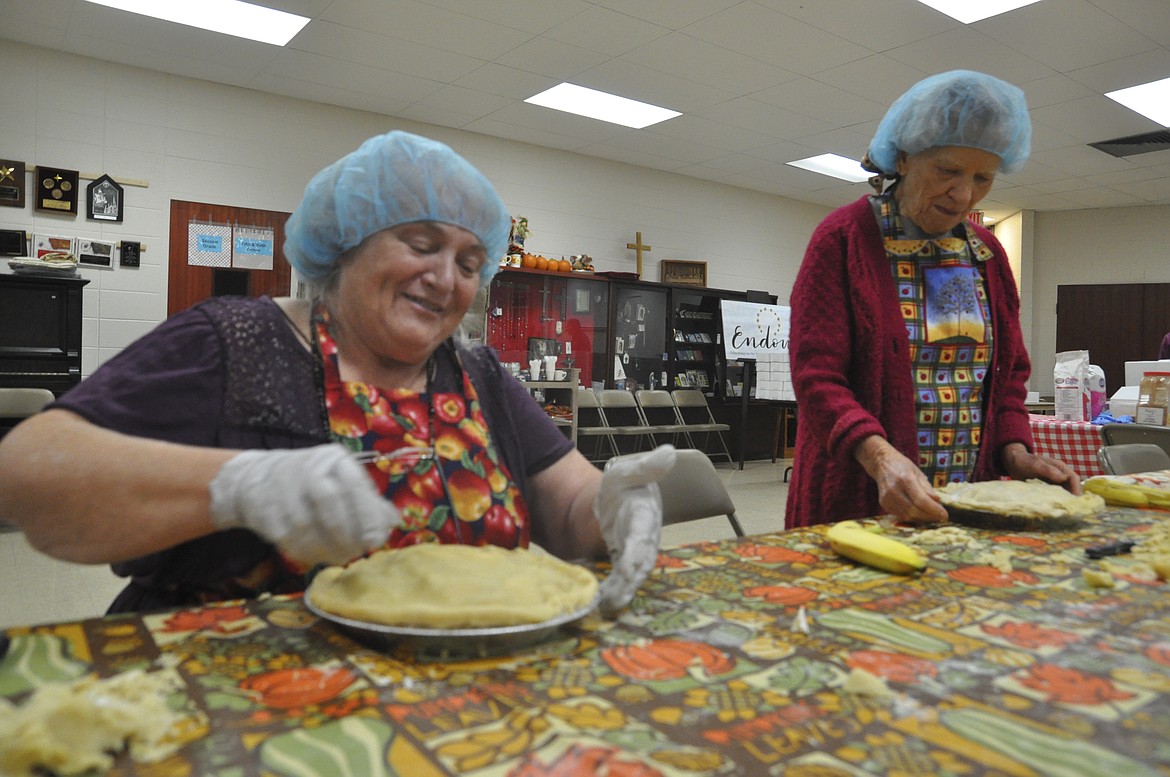 Margaret Clay, left, and Dorothy Jenson, pinch crust on apple pies which will be sold Saturday at the Fall Apple Fest at Immaculate Conception Catholic Church in Polson. (Ashley Fox/Lake County Leader)