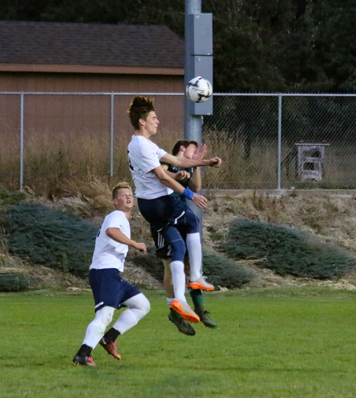 Photo by Mandi Bateman.
Judah Draxlir heading ball with Pacen Pluid standing by