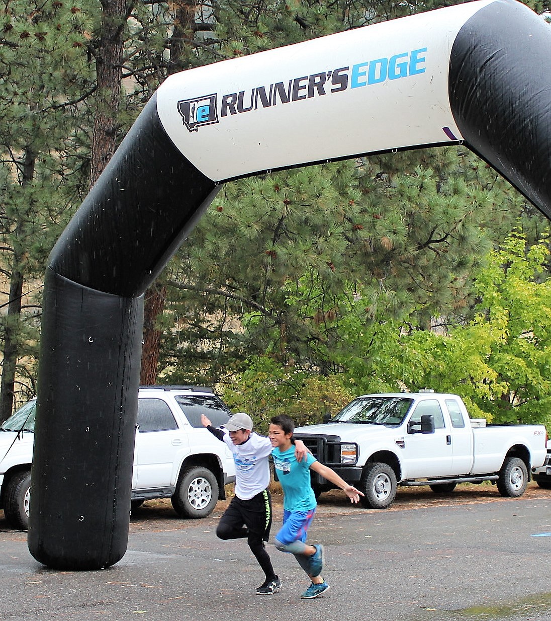 Lucas Kovalsky and Decker Milendar cross the finish line together during the 5K &#147;Run for the Pool&#148; with a time of 24:40. Both attend Superior School in grades 6 and 7. (Kathleen Woodford/Mineral Independent).