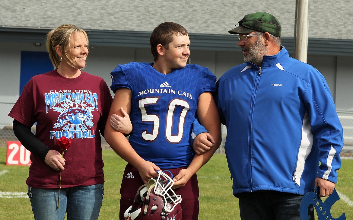 Tucker McLees is escorted with his parents before the game on Saturday. (Photo by Frankie Kelly).