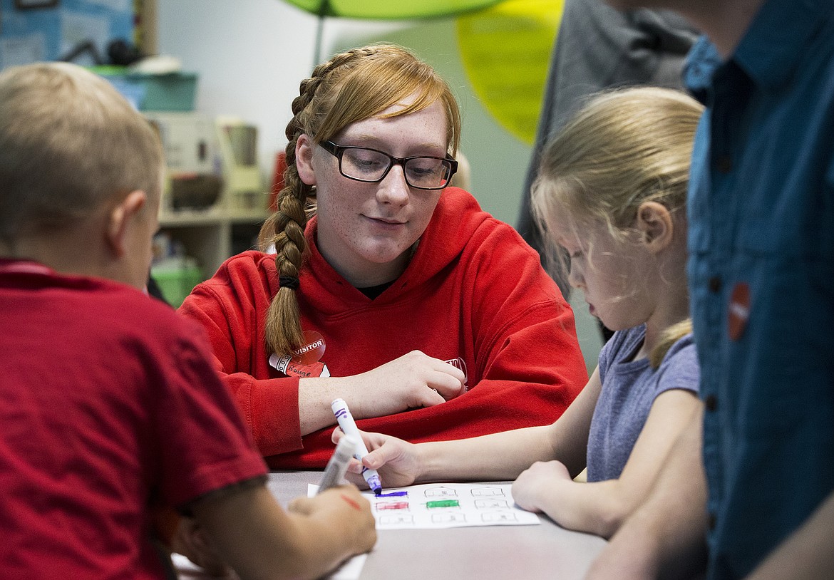 Photos: LOREN BENOIT/Press
Lake City High School junior Alexis Cummins helps June Calderwood fill in a French coloring sheet on Wednesday at Skyway Elementary School.