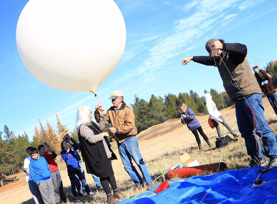 (Photo by MARY MALONE)
Students from Dinah Gaddie&#146;s Sandpoint Middle School class and Laura Spurway&#146;s Rathdrum gifted and talented class look on as Barb and Marty Mueller, founders of Gizmo-CDA, hold onto a 1,200 gram weather balloon filled with helium as Ian Gaddie, right, prepares the line and payload for lift off into near space on Friday as part of a Gizmo2Extremes project.
