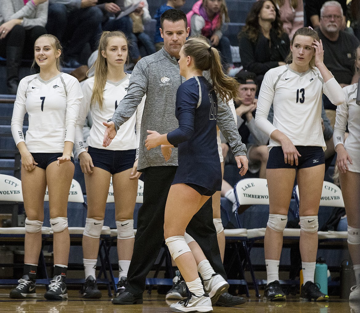 LOREN BENOIT/Press
Lake City volleyball coach Mike Summers congratulates senior libero Ashley Reyes, center, as she comes off the court during last week&#146;s 5A Region 1 championship match against Post Falls.