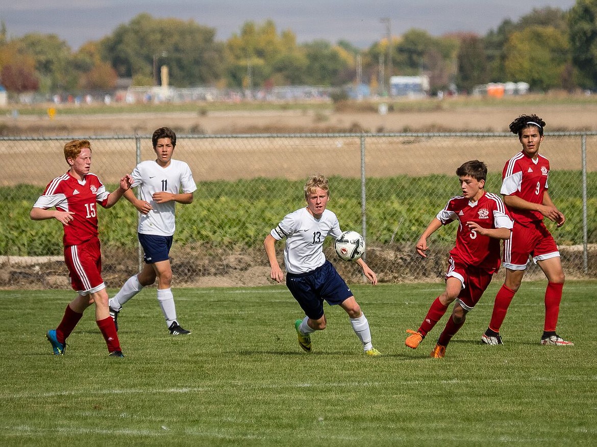 Photos by Doug Beazer
Tyler Beazer fights Weiser for the ball while Daniel Walker supports during the Badgers&#146; opening match at the 3A state tournament