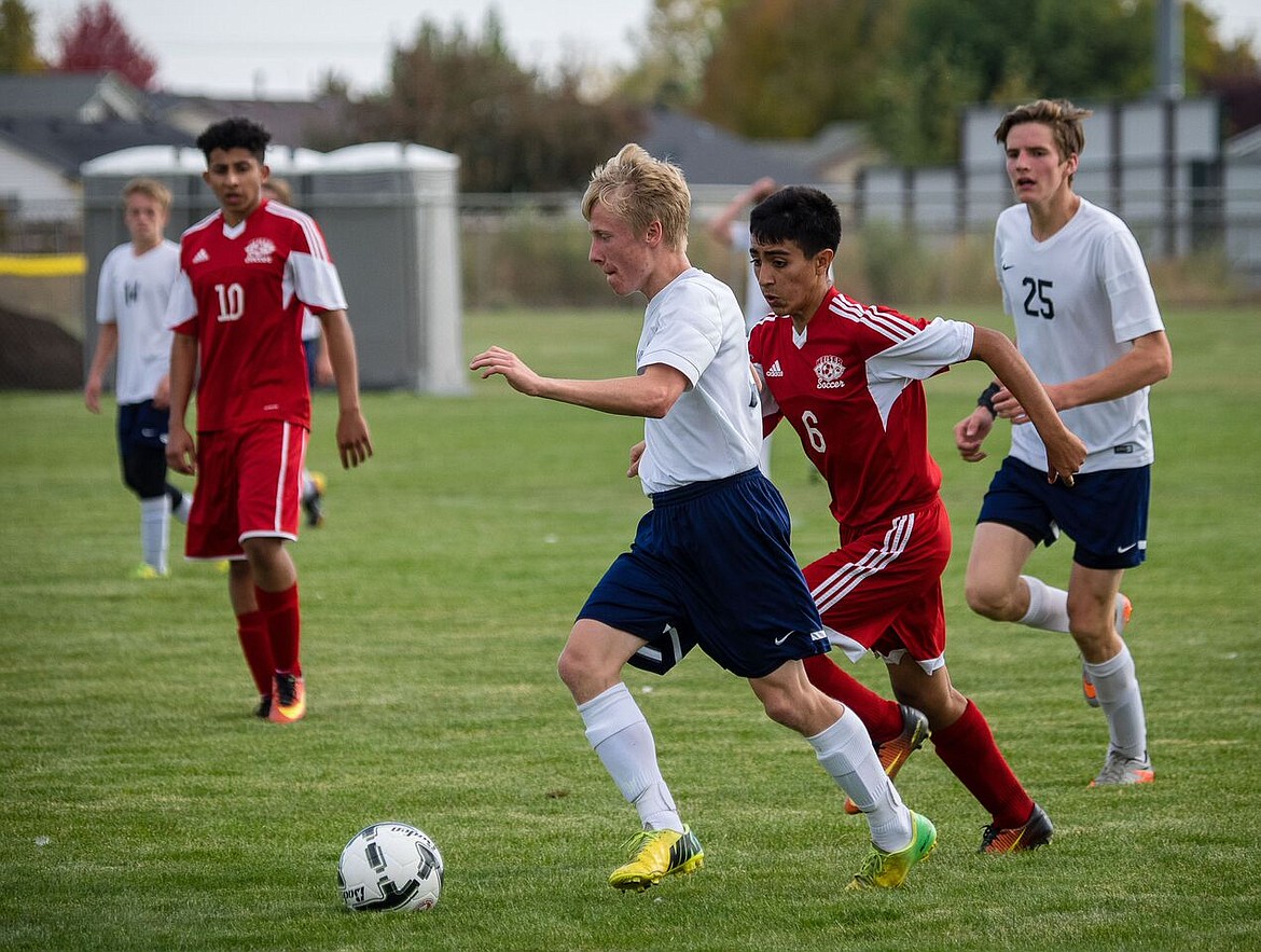 Photo by Doug Beazer
Tyler Beazer maintains possession from Weiser, while Judah Draxlir looks on.