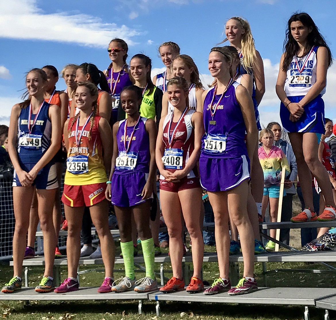 POLSON HIGH School runner Bea Frissell (far right, bottom row) stands on the podium after capturing her first-ever MHSA Class A state cross country title. Niama Crowl (middle, bottom row) also stands on the podium after her top-5 finish. Molly Sitter, the other Lady Pirate to earn All-State honors, stands on podium (middle, back row) after she finished in the top-15. The Polson Lady Pirates finished third in the MHSA Class A state cross country meet in Helena. (photo courtesy of Lindsay Rossmiller, 406 MT Sports)