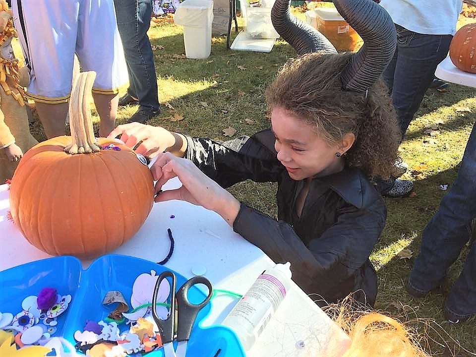 Mandi Saroglou decorates her pumpkin during Mineral County Library&#146;s pumpkin decorating contest last Saturday. (Photo by Angie Hopwood).