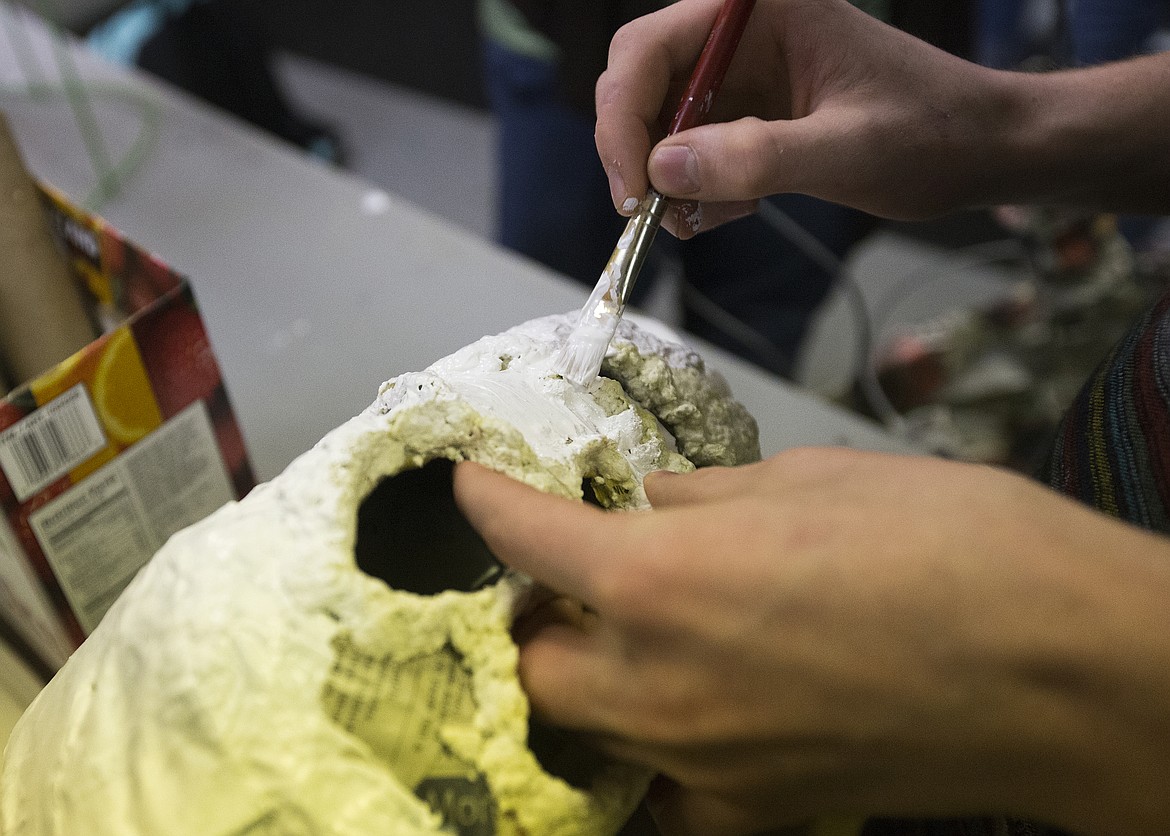 LOREN BENOIT/PressEthan Stein paints the skull of a newspaper skeleton at a workshop last Thursday at Emerge.