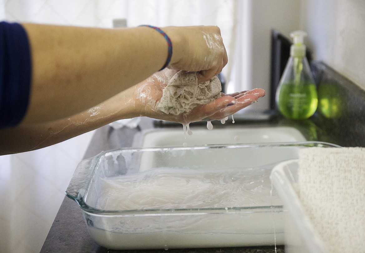 LOREN BENOIT/PressBelly casting artist Rayne Andrews dips a plaster strip in water.