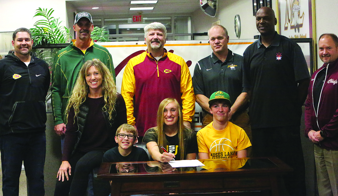 Connor Vanderweyst/Columbia Basin Herald
Abby Rathbun (middle seated) poses with (left to right) Brant Mayo, Greg Rathbun, Jen Rathbun, Matt Strophy, Chad Utter, JD Taylor, Loren Sandhop, (seated) Taggart Rathbun and Tell Rathbun after signing her national letter of intent to the University of San Francisco.