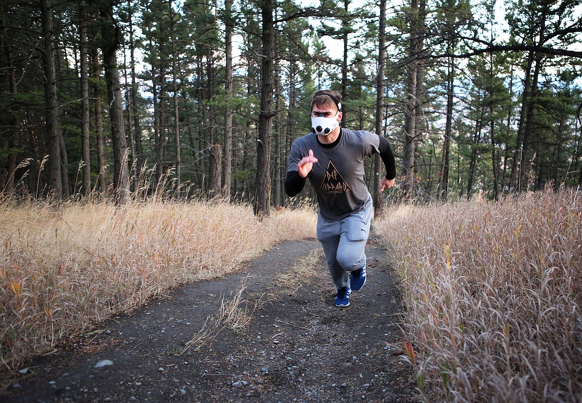 Amateur boxer Taylor Reed runs up a trail at Lone Pine State Park in the early morning hours of Monday, Oct. 23. Reed trains with an altitude mask that simulates the effects of running at elevation, forcing the body to operate with less oxygen. (Mackenzie Reiss/Daily Inter Lake)