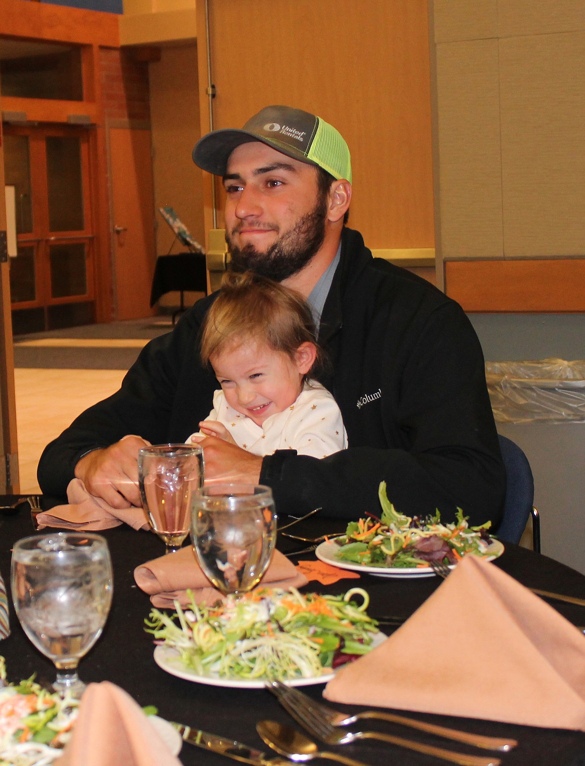 Joel Martin/Columbia Basin Herald
Two-year-old Kyler Carlile waits eagerly on her dad Justin&#146;s lap for dinner at the Moses Lake Christian Academy banquet and auction Saturday evening.