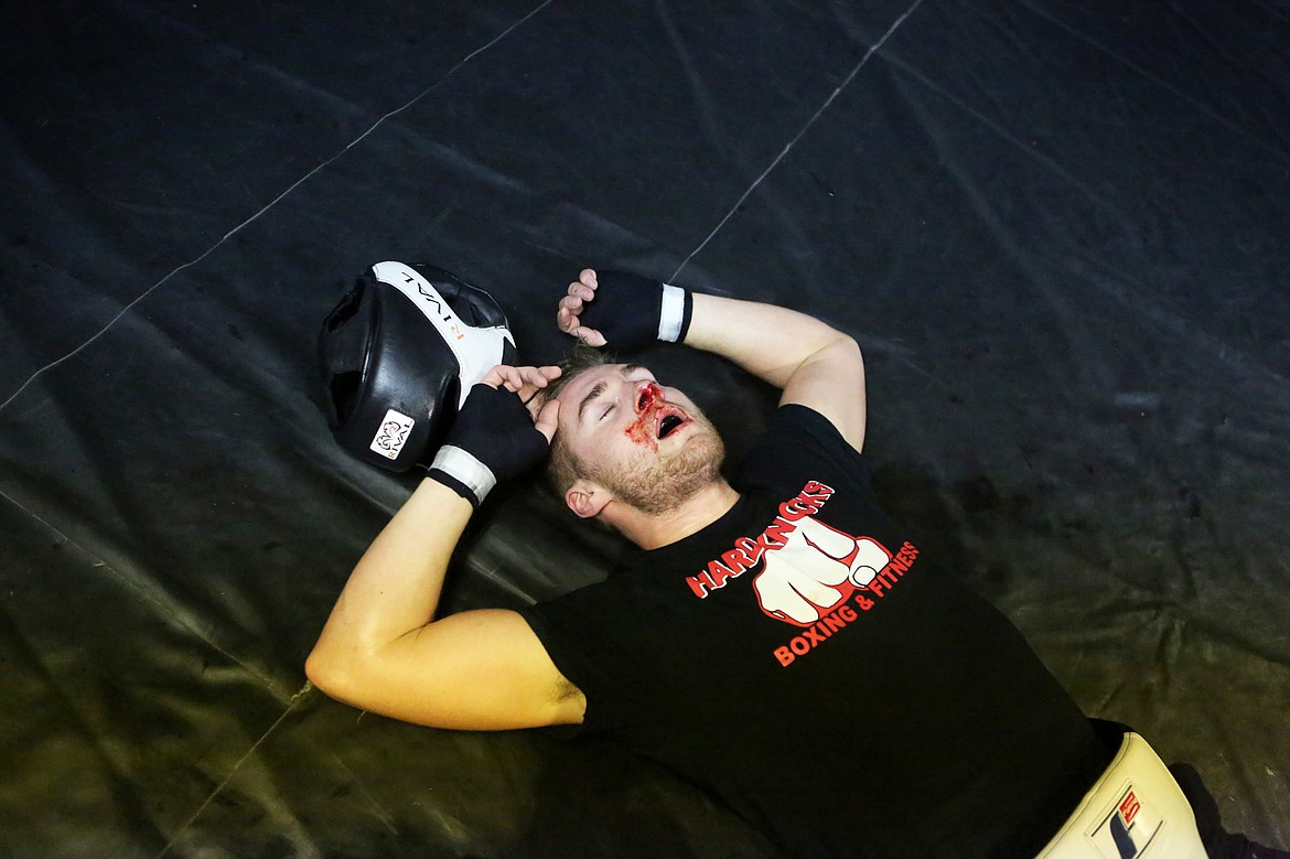 Taylor Reed, 20, falls to the mat in exhaustion after an eight-round sparring session with his coach and professional boxer Jesse Uhde at Hard Knocks Boxing and Fitness in Evergreen. More photos on page C2.