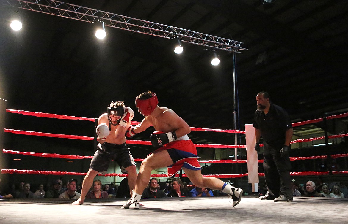 Taylor Reed, center, slams into opponent Marshall Sutherland during their Oct. 28 fight at Fight Night 6 in Kalispell. Reed was victorious, bringing him to a seven-fight winning streak. (Mackenzie Reiss/Daily Inter Lake)