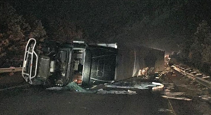 A semi-truck carrying apples flipped onto its side on Saturday evening, Nov. 4, sending the driver to the hospital and closed Interstate 90 when refrigerator fuel leaked onto the road near mile marker 65. (Photo courtesy of Frenchtown Rural Fire Department)