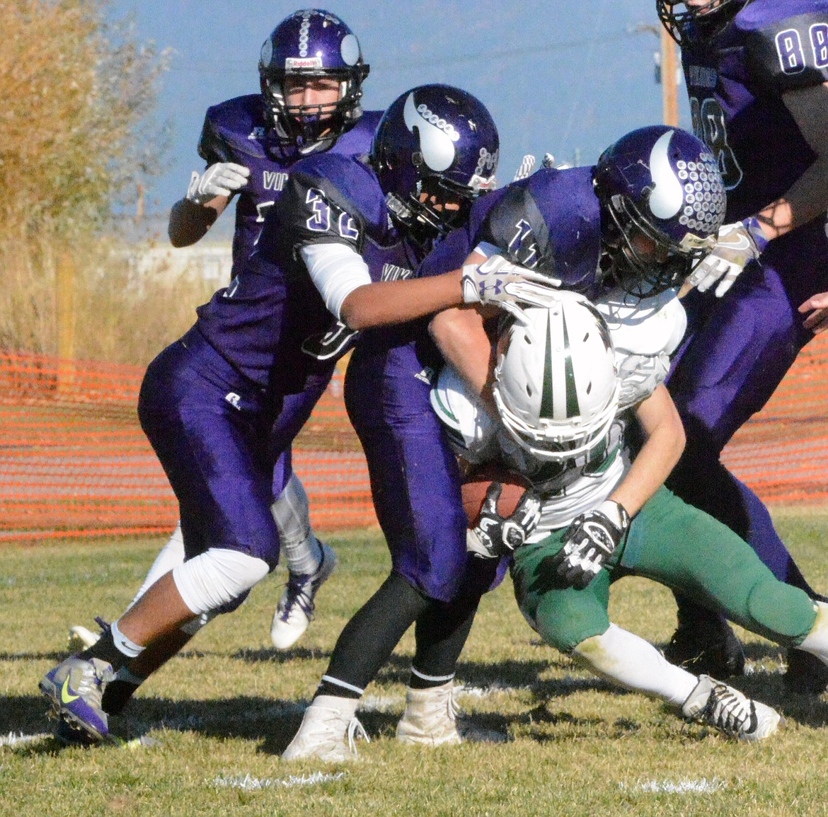 CHARLO TACKLERS Dominic Marquez (32), Garett Vaughan (11), and  Darien Liberty (88) gang-tackle Joliet running back Trey Oswald during the first round of the MHSA Class C, 8-man playoffs Saturday afternoon at Charlo High School. (Jason Blasco/Lake County Leader)