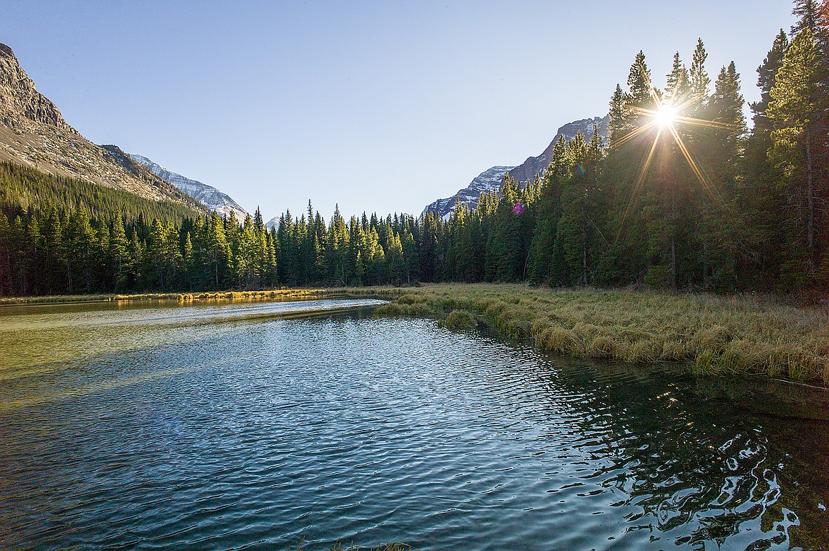 The sun sets over a backwater along the trail.