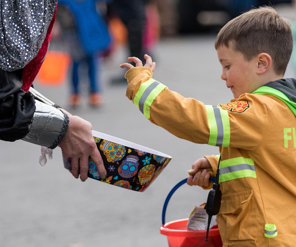 Liam Sunell reaches for candy at the trunk-or-treat event next to the Libby Memorial Events Center Tuesday.