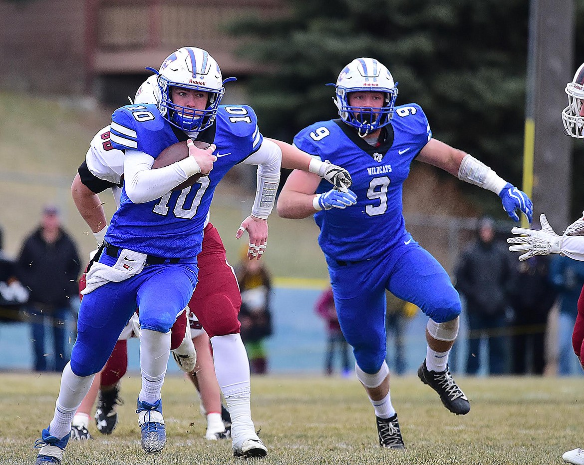 Columbia Falls quarterback Austin Green (10) gets by the Hamilton defense as teammate Logan Kolodejchuk looks to through a block against Hamiltoon Saturday in the state A championship.