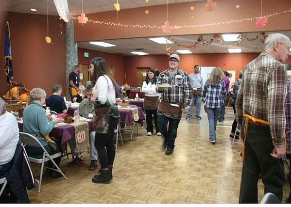 Logan Crossley, 20, of Coeur d&#146;Alene, center right, races plates to guests during the free community Thanksgiving Day meal at Lake City Center in 2015. This is the 20th year for the meal, which will be served from noon to 2 p.m. on Thanksgiving. (DEVIN HEILMAN/Press file)