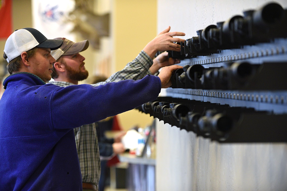 Haakon Sande, left, and Jim Vincent, both of Kalispell, check out a display of rifle scopes at an open house event at U.S. Optics in Kalispell on Friday, Nov. 17. (Casey Kreider/Daily Inter Lake)