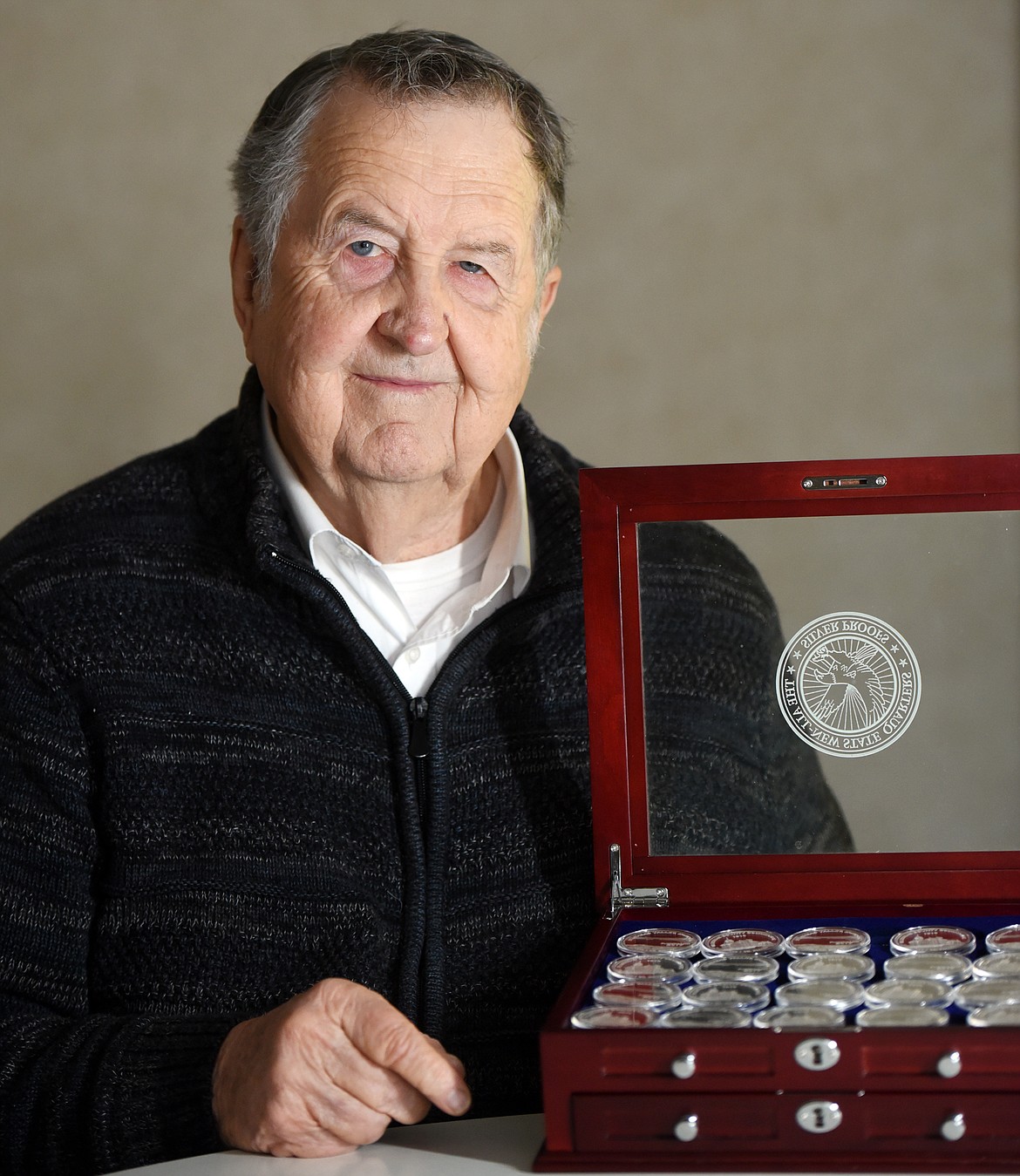 Jim Sappington is pictured with a set of The Uniqueness of Montana silver collector coins on Nov. 7. This 2017 coin features a view of the Flathead County Courthouse as it looked in 1910 and a view of Flathead Lake. (Brenda Ahearn/Daily Inter Lake)