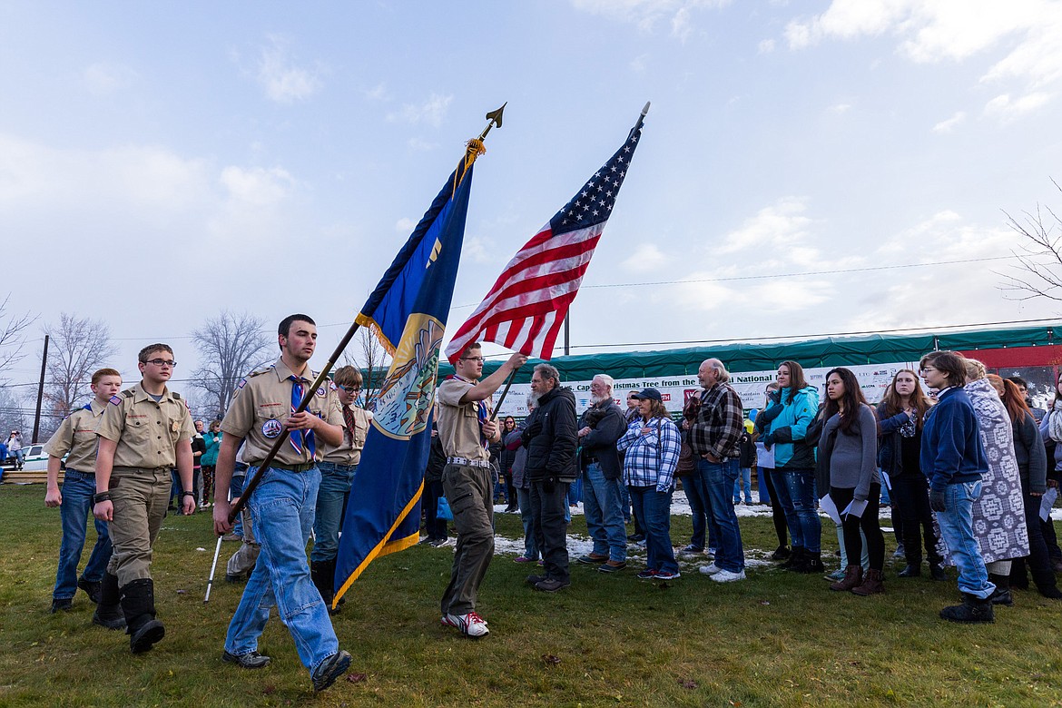 Boy Scouts present the Montana and American flags for the Pledge of Allegience Tuesday during a send-off event for the Capitol Christmas Tree contained in the trailer in the background. (John Blodgett/The Western News)