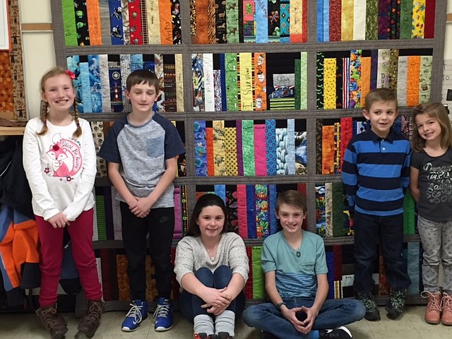 Canyon Elementary students stand in front of the quilt that will be raffled off during the auction tonight at the school. The quilt was made by Kay Stovern and features each students name &#151; written by the student themselves. This ham and turkey dinner is an annual event that raises the money for fund field trips, playground equipment, science supplies, teacher classroom support, and much more. Dinner begins at 4 p.m., carnival games/ cake walk at 5:30 p.m., live auction at 6 p.m., and silent auction from 4 to 6 p.m.

Photo courtesy of JENNIFER FERGUSON