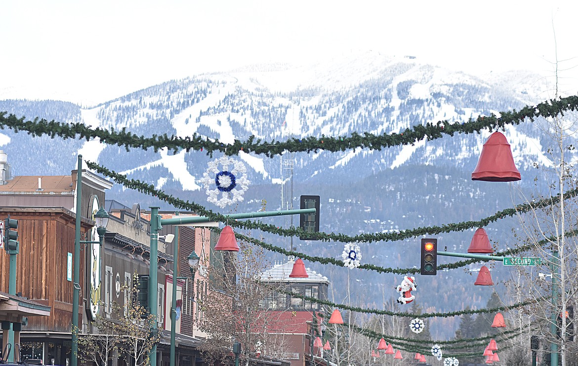 Volunteers helped hang the winter decorations downtown Sunday morning. For more than 50 years the decorations have brightened Whitefish. (Heidi Desch/Whitefish Pilot)