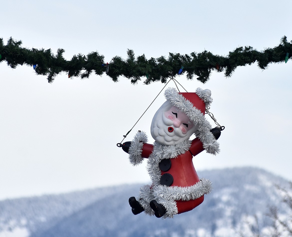 Volunteers helped hang the winter decorations downtown Sunday morning. For more than 50 years the decorations have brightened Whitefish. (Heidi Desch/Whitefish Pilot)