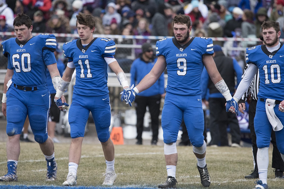 Captains Hayden Falkner, Ben Windauer, Logan Kolodejchuk and Austin Green walk to the center of the field for the coin toss.