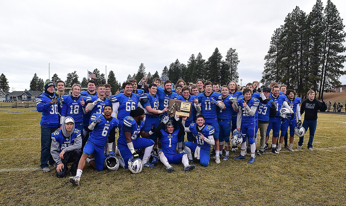 The Columbia Falls football team poses with the state A championship trophy Saturday after beating Hamilton, 24-16.