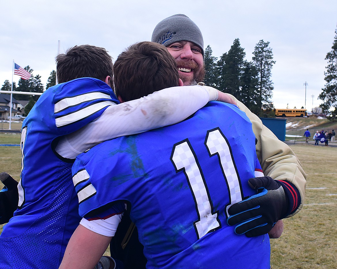 Coach Jaxon Schweikert gets a hug from Austin Green, left, and Ben Windauer.